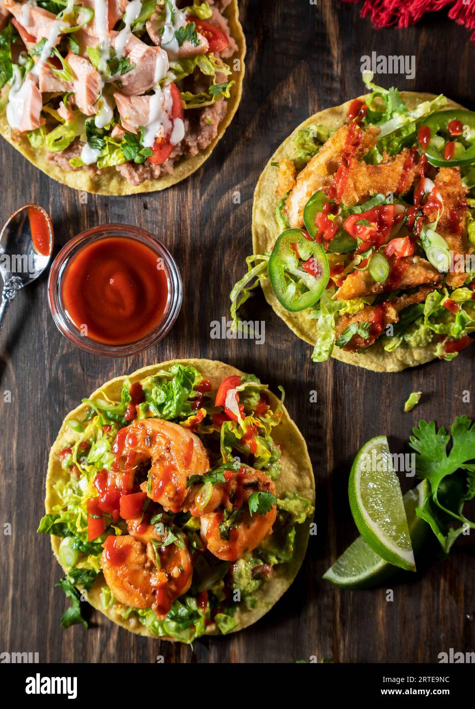 Tostadas avec garnitures variées : saumon, poulet frit pané et crevettes sautées Banque D'Images