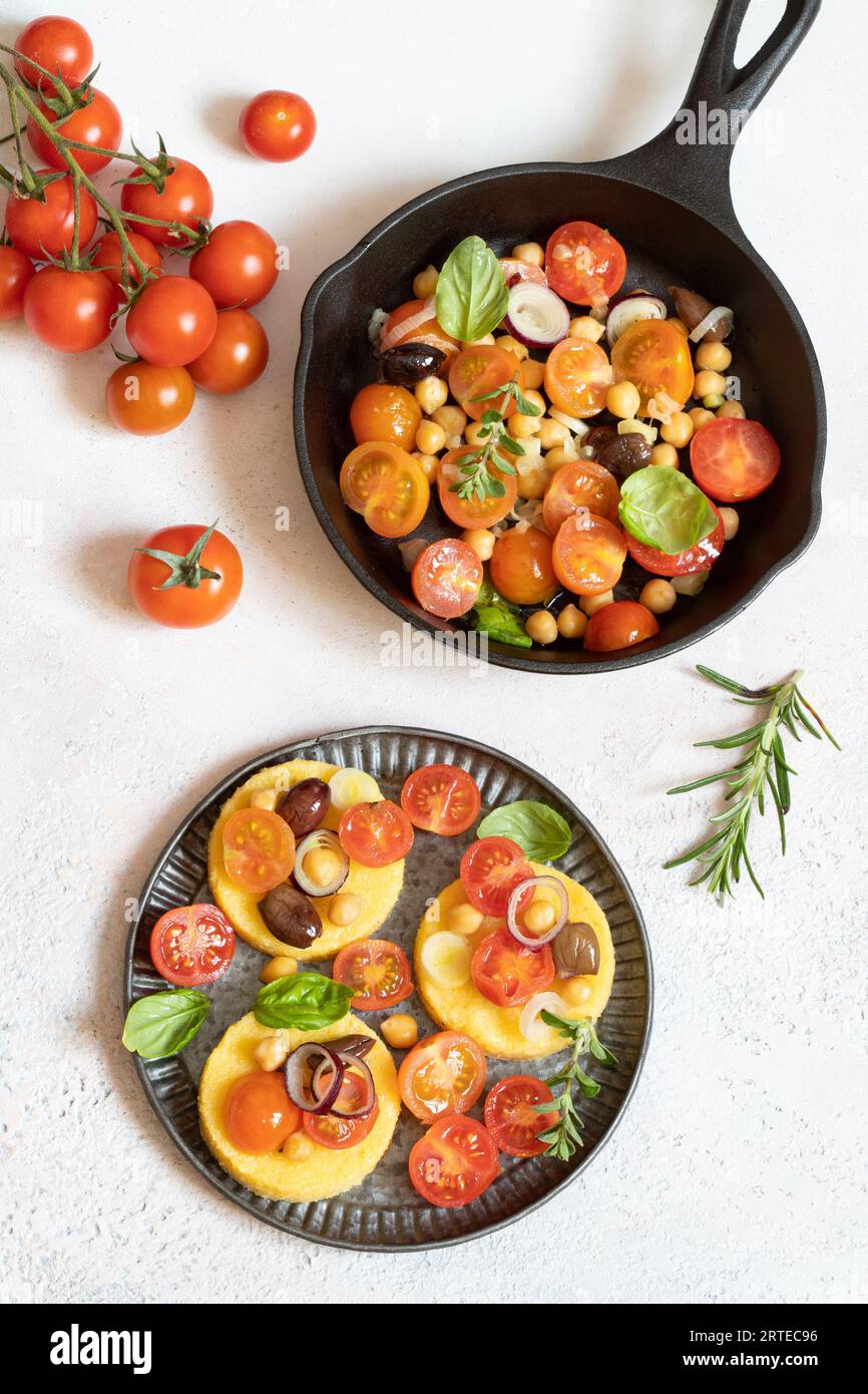 Polenta thalers avec tomates cerises, pois chiches et oignons verts Banque D'Images