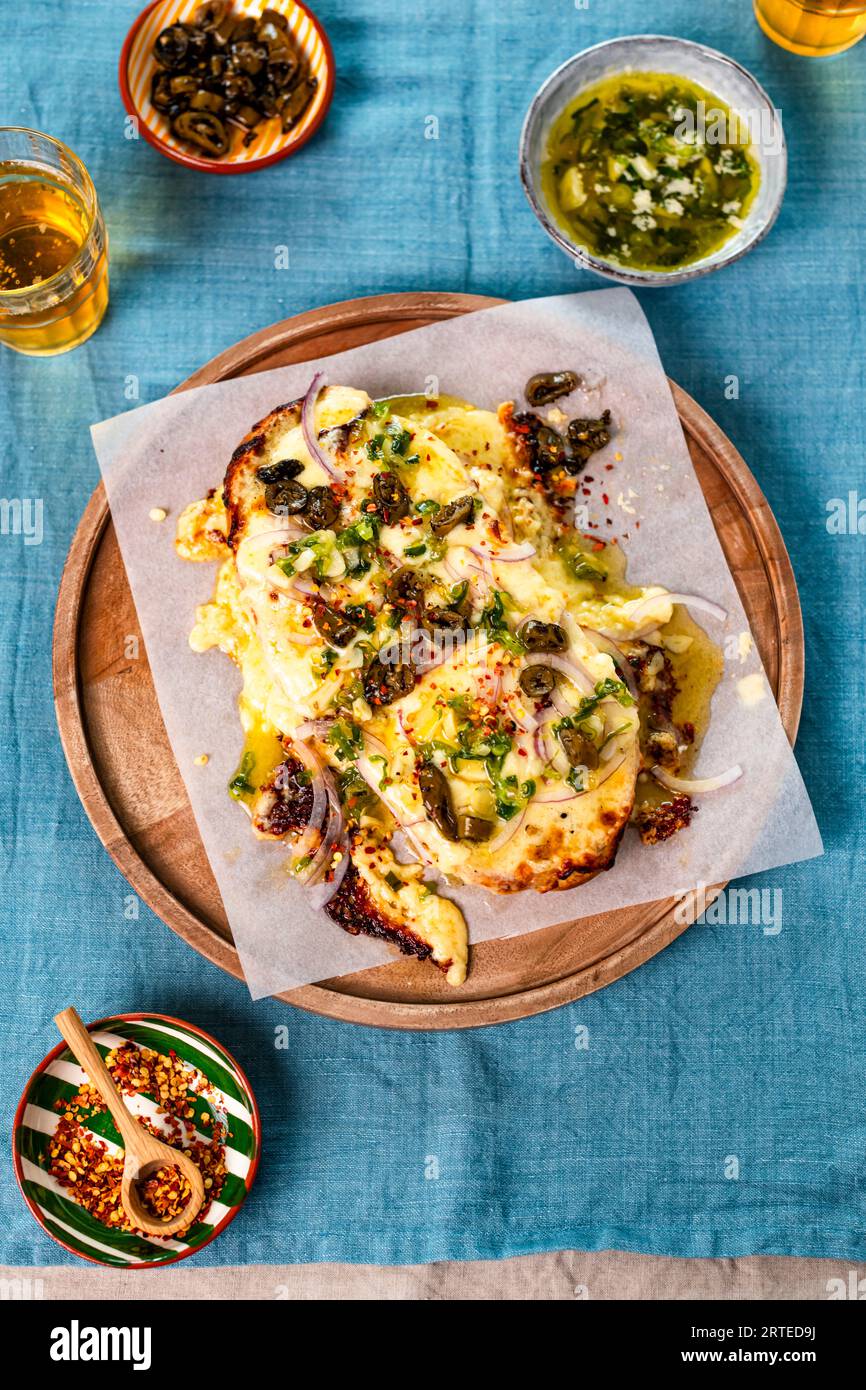Fromage grillé géant avec olives, Jalapeno et flocons de piment Banque D'Images