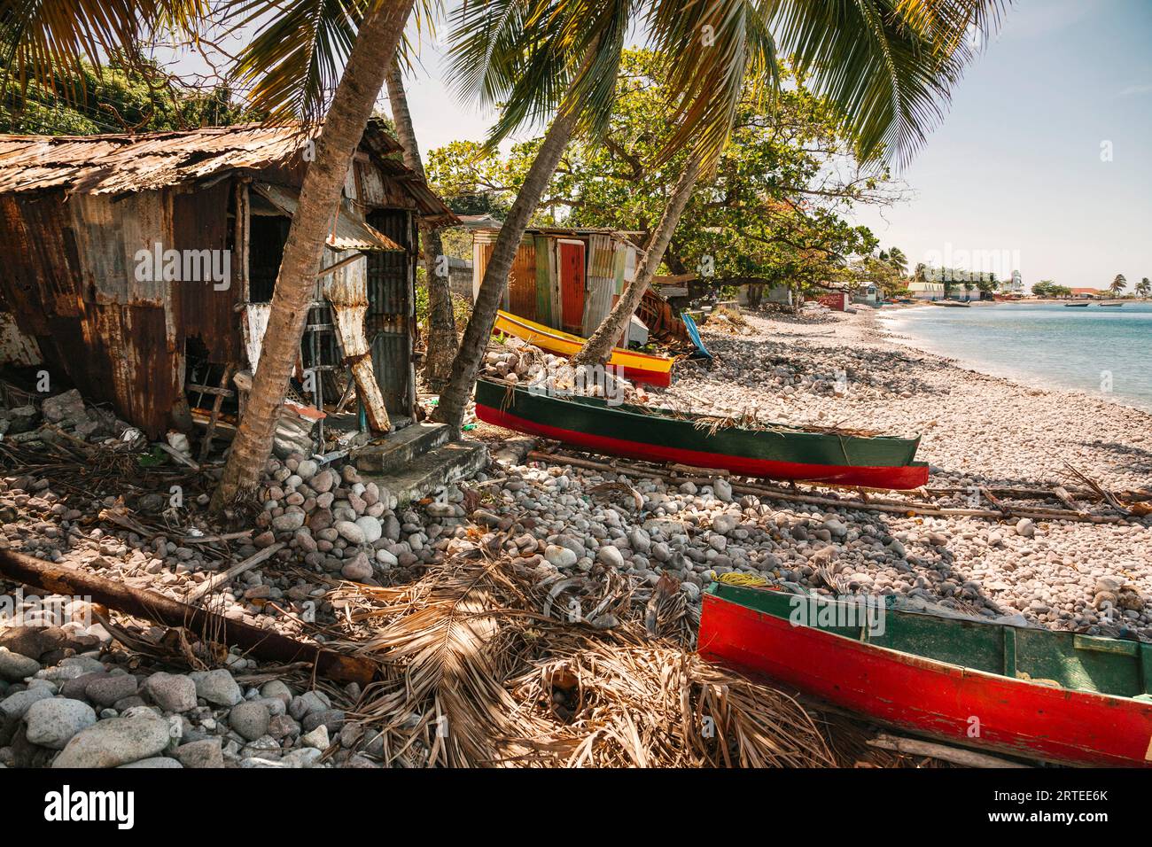 Des cabanes de pêche et des bateaux de pêche traditionnels à pirogue se sont échoués le long de la rive du village de Scotts Head dans la baie de Soufriere sur l'île de Dominique Banque D'Images