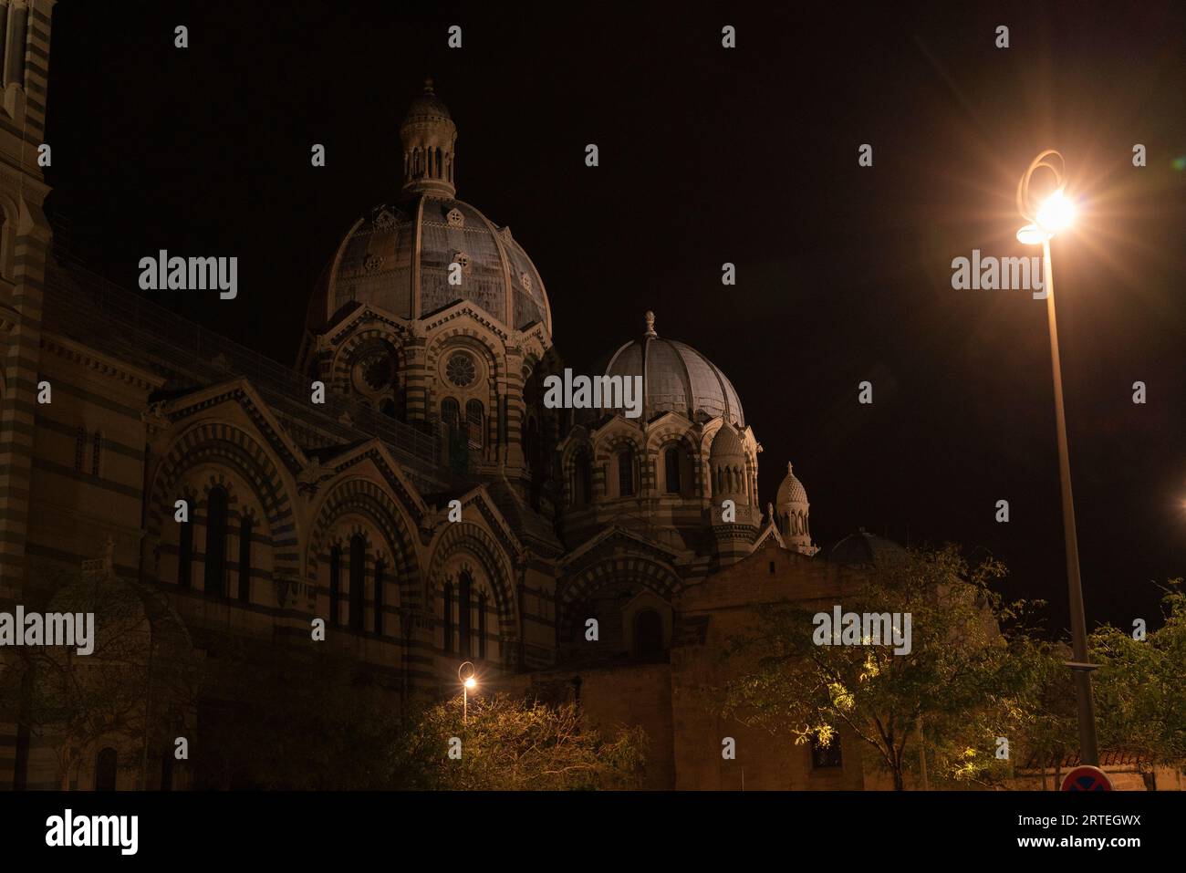 Dômes sur la cathédrale historique de Marseille la nuit, avec un lampadaire brillant dans l'obscurité ; Marseille, France Banque D'Images