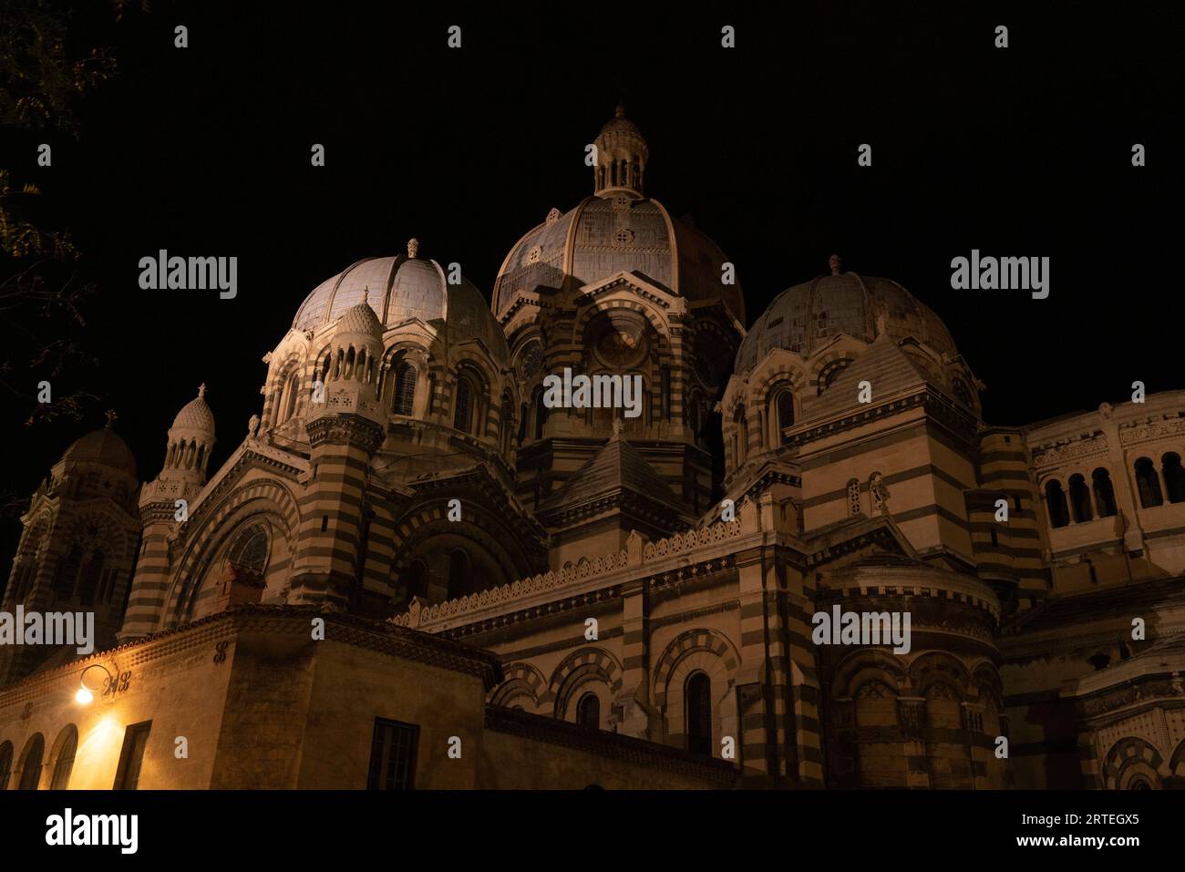 Dômes sur la cathédrale historique de Marseille la nuit, avec un lampadaire brillant dans l'obscurité ; Marseille, France Banque D'Images