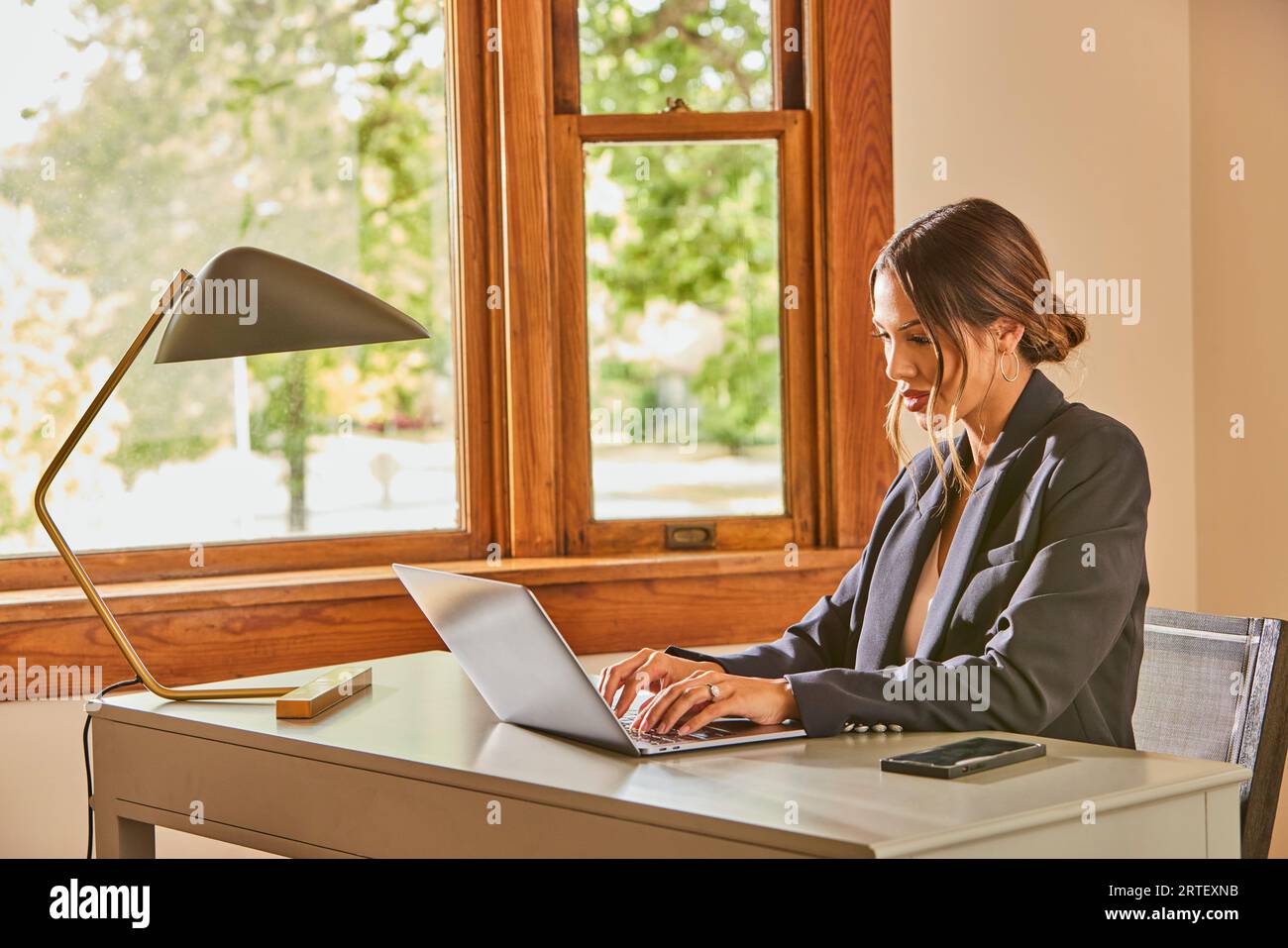 Femme utilisant un ordinateur portable et au bureau à la maison Banque D'Images