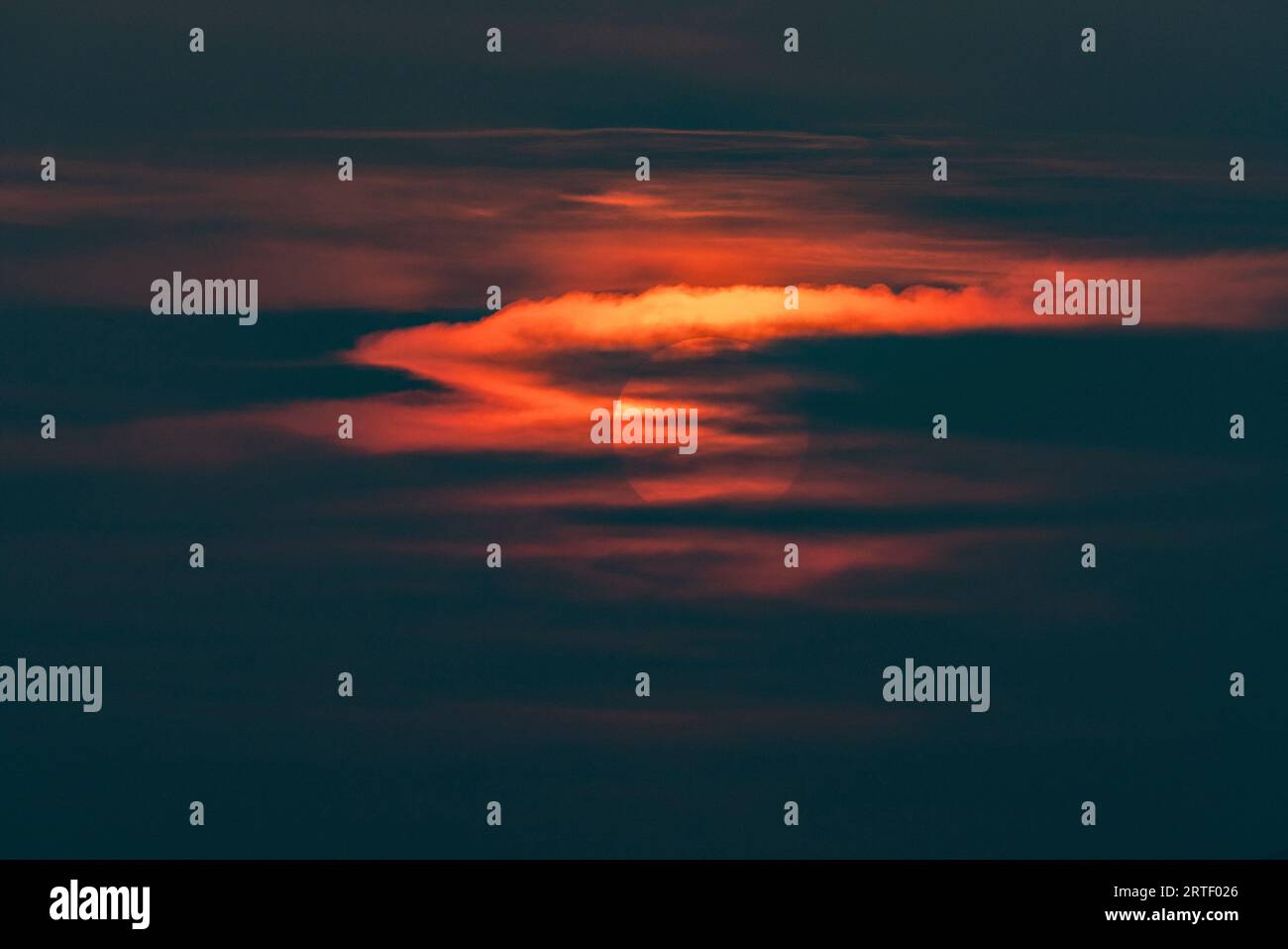 Soleil derrière les nuages au coucher du soleil Banque D'Images