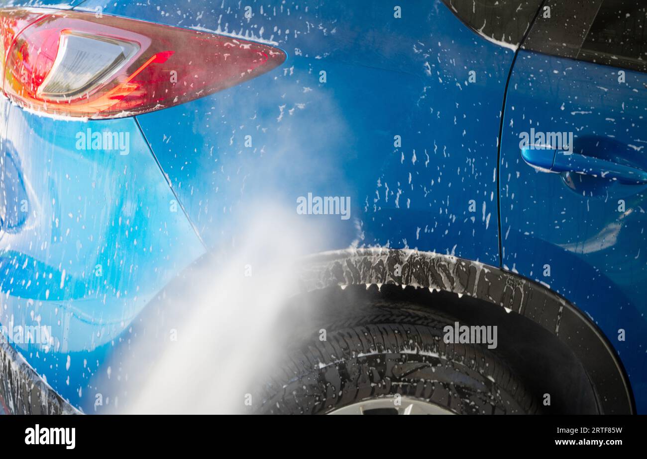 Lavage de voiture avec pulvérisation d'eau à haute pression. Nettoyage de voiture. Concept de service auto Care. Nettoyage de véhicules. Pulvérisation d'eau sur une voiture pour nettoyer la mousse blanche Banque D'Images