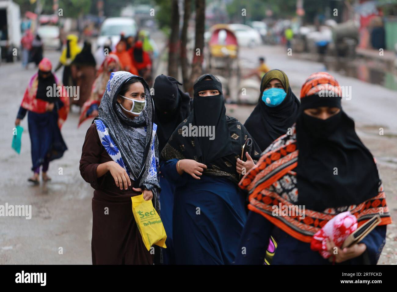 DHAKA, BANGLADESH - 28 AVRIL 2020 : des travailleurs du vêtement marchent dans la rue après la réouverture des usines pendant le confinement à l’échelle du pays comme mesure préventive contre la pandémie de coronavirus COVID-19 à Dhaka, au Bangladesh, le 28 avril 2020. Banque D'Images