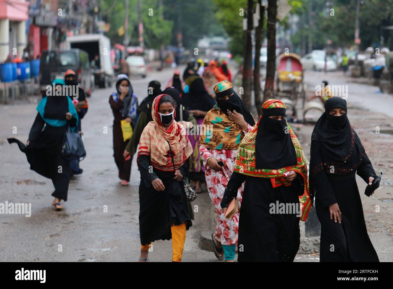 DHAKA, BANGLADESH - 28 AVRIL 2020 : des travailleurs du vêtement marchent dans la rue après la réouverture des usines pendant le confinement à l’échelle du pays comme mesure préventive contre la pandémie de coronavirus COVID-19 à Dhaka, au Bangladesh, le 28 avril 2020. Banque D'Images