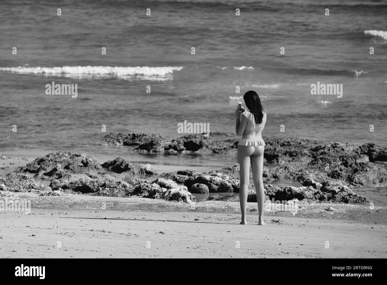 Femme vue de derrière sur la plage un jour d'été. Banque D'Images