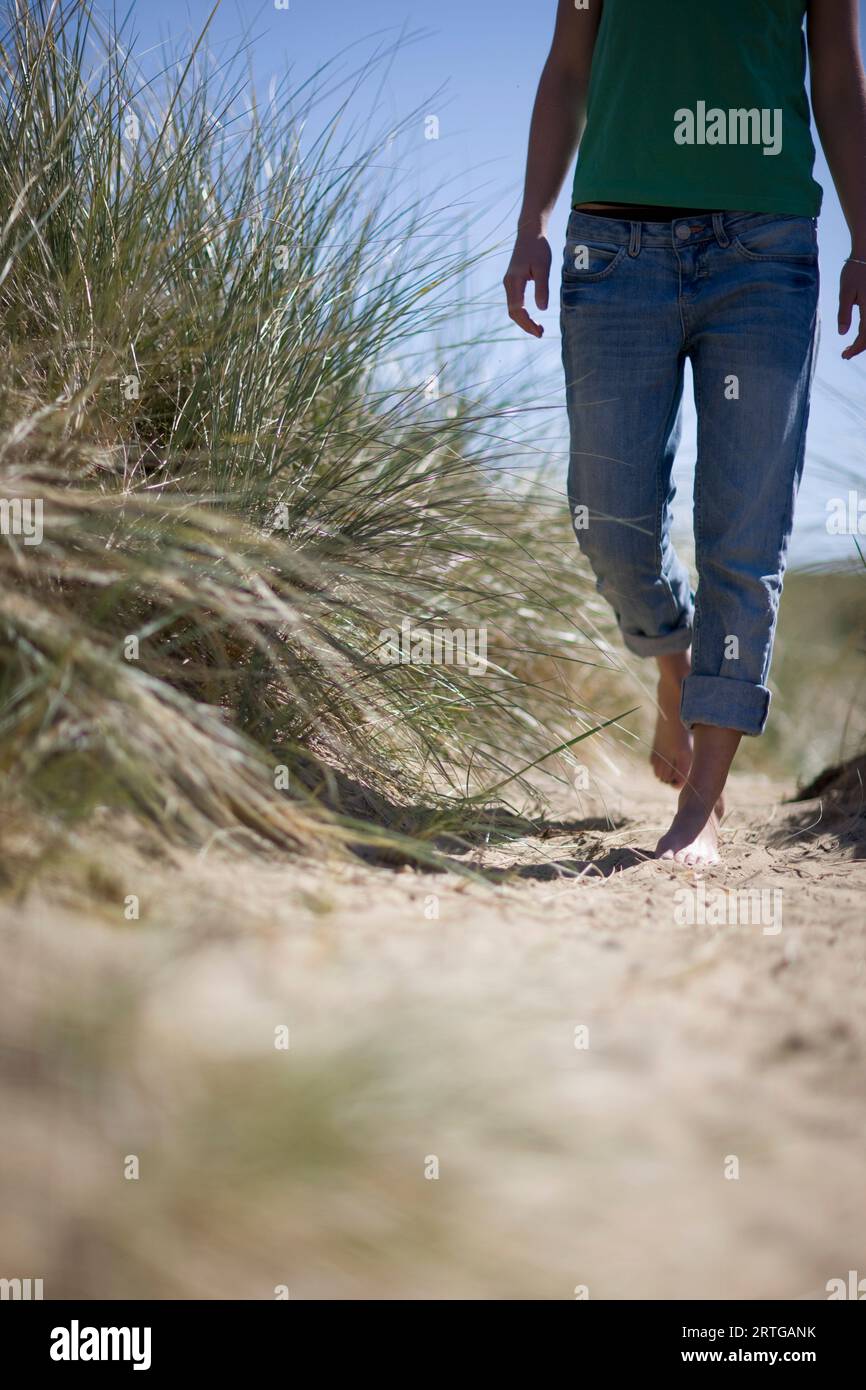 Jeune femme pieds nus marchant Banque D'Images