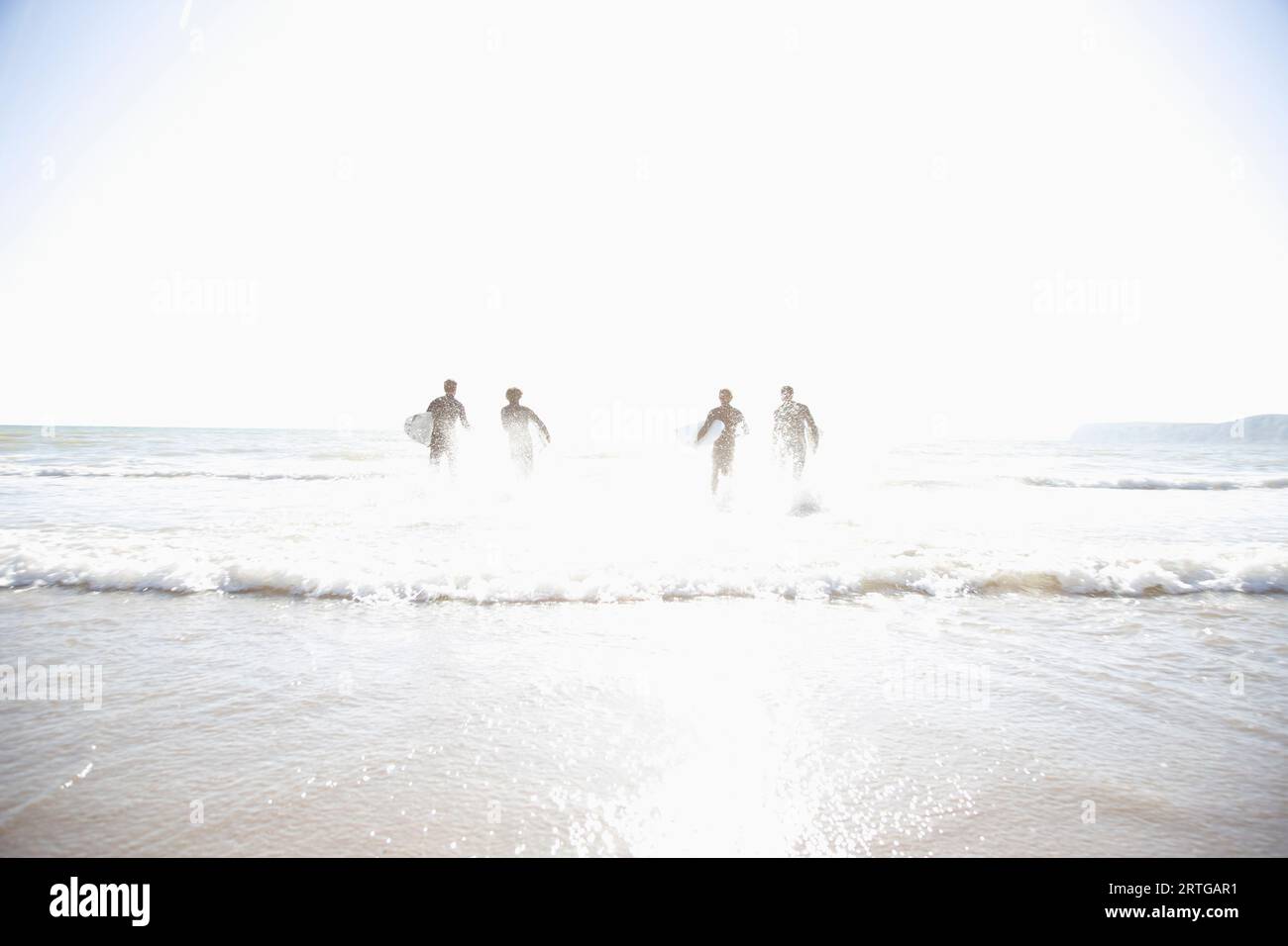 Silhouette de surfers s'exécutant dans la mer Banque D'Images