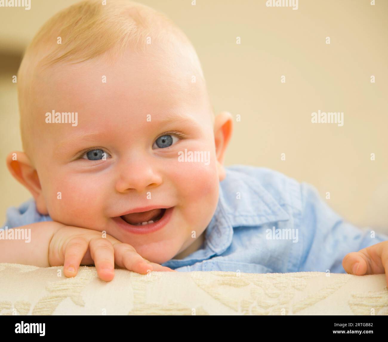 Close up of cute baby boy avec face en appui sur les mains Banque D'Images