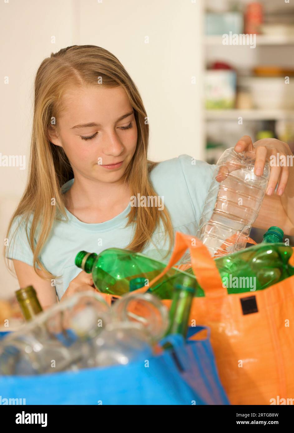 Jeune fille des bouteilles en plastique de recyclage Banque D'Images