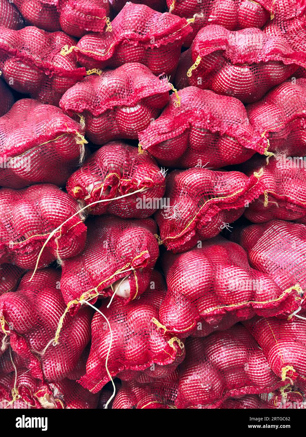 Vue du dessus des bouquets d'oignons dans des sacs rouges Banque D'Images