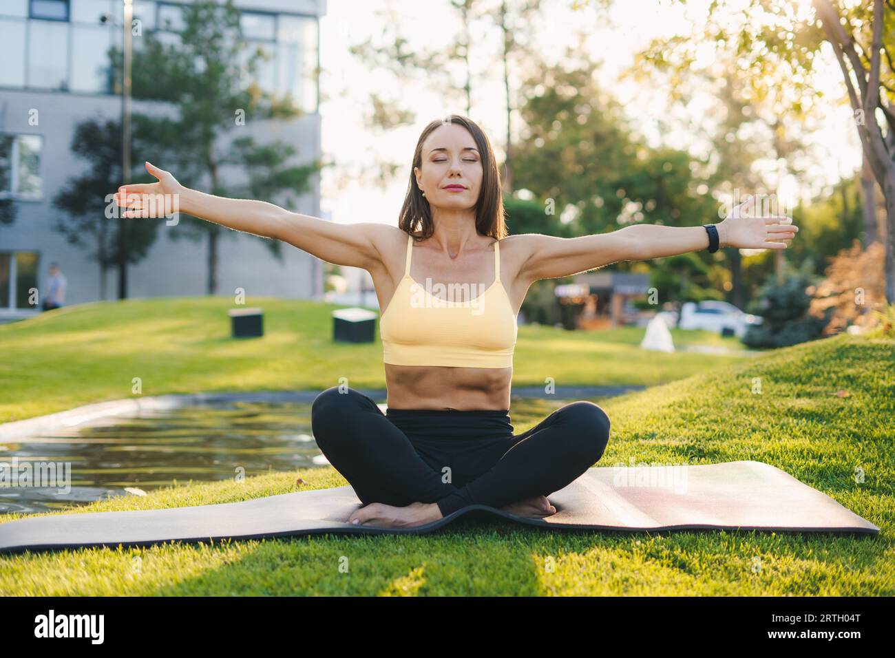 Vue de face d'une femme mature pratiquant le yoga dans le parc. Mode de vie actif. Femme pratiquant le yoga. Mode de vie sain. Banque D'Images