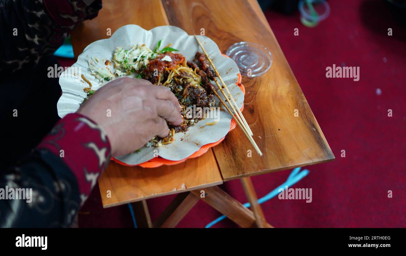 mangez avec cinq doigts sur une petite table sans cuillère ni fourchette. Banque D'Images