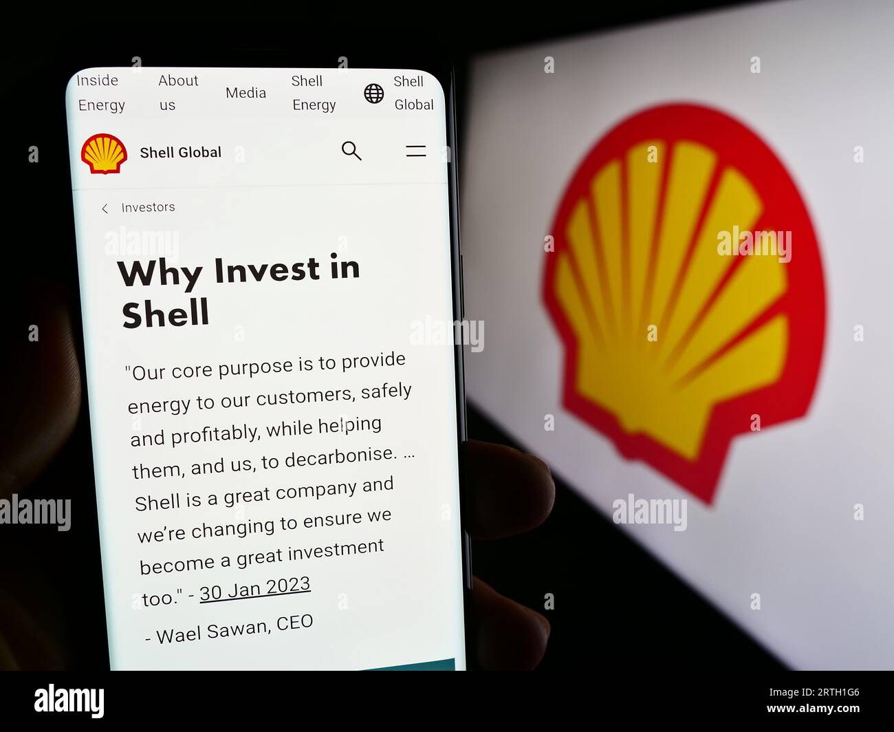 Personne tenant un smartphone avec la page Web de la société pétrolière et gazière britannique Shell plc sur l'écran devant le logo. Concentrez-vous sur le centre de l'écran du téléphone. Banque D'Images