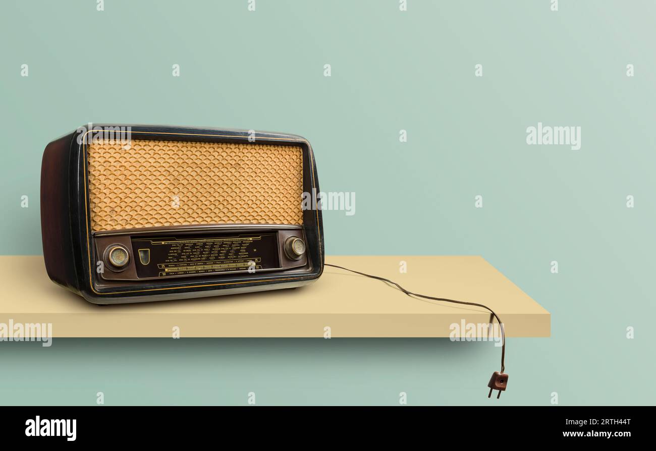 Radio antique débranchée sur l'étagère avec fond vintage. Banque D'Images