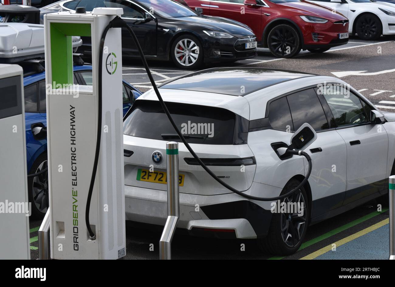 Un véhicule électrique blanc ou un véhicule électrique rechargeable dans une station-service sur une route principale dans le sud-ouest de l'Angleterre Banque D'Images