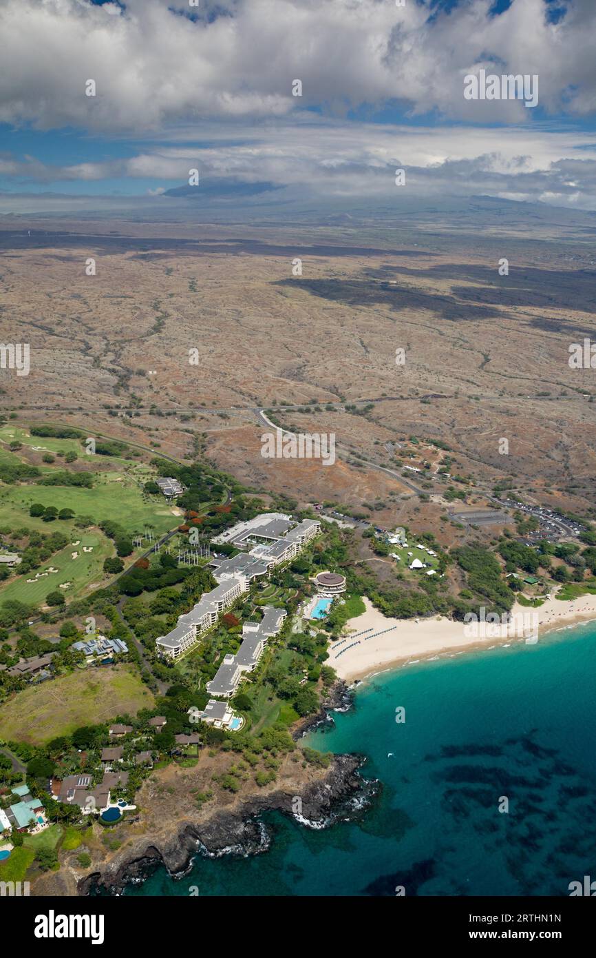 Vue aérienne de Hapuna Beach sur la côte ouest de Big Island, Hawaii, USA, avec une vue sur le Mauna Kea couvert de nuages Banque D'Images