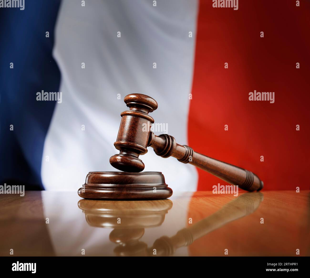 Marteau en bois d'acajou sur table en bois brillant, drapeau de France en arrière-plan Banque D'Images
