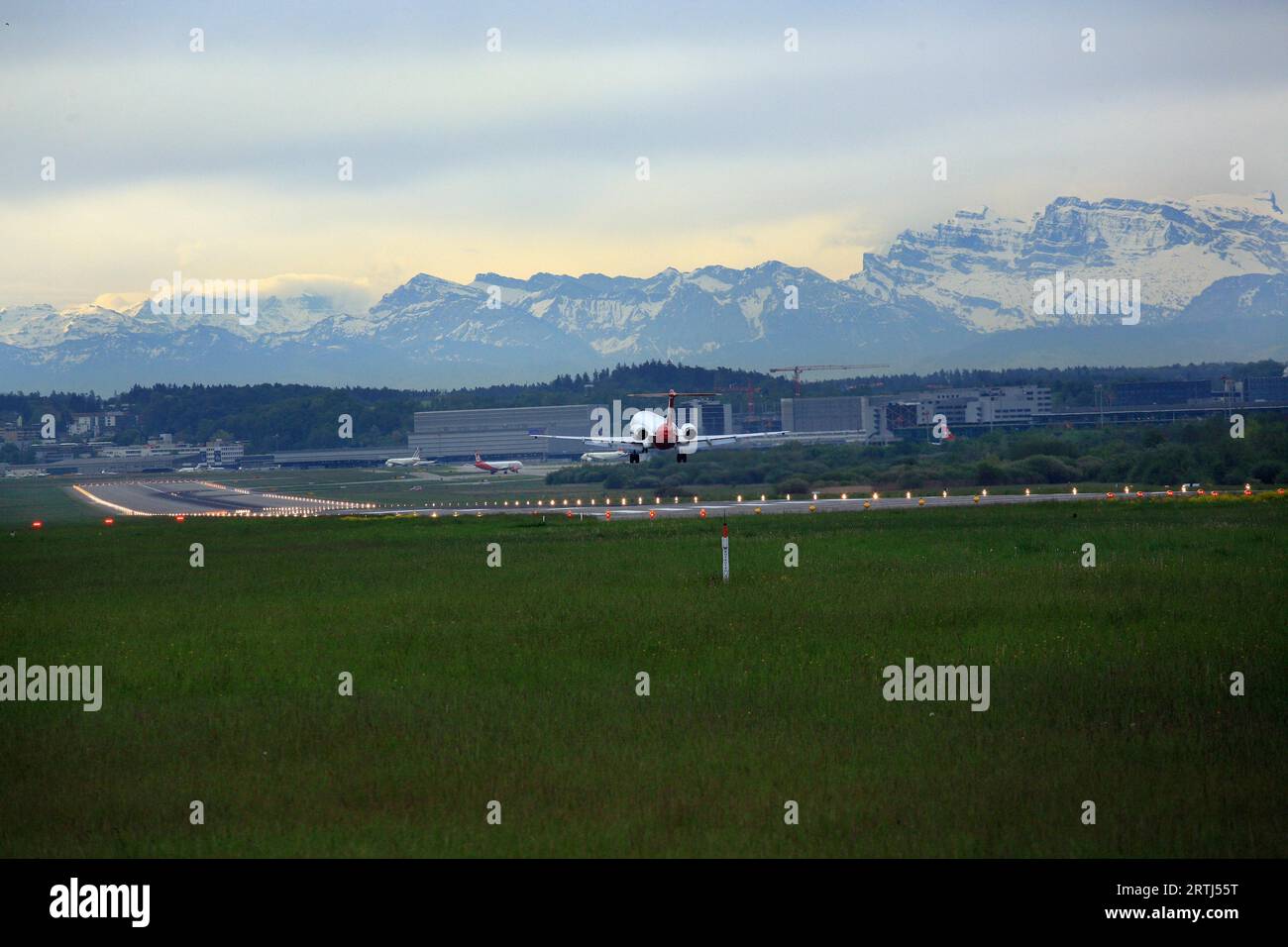 Atterrissage d'un Fokker 100 à l'aéroport de Zurich. Vue sur les Alpes suisses Banque D'Images