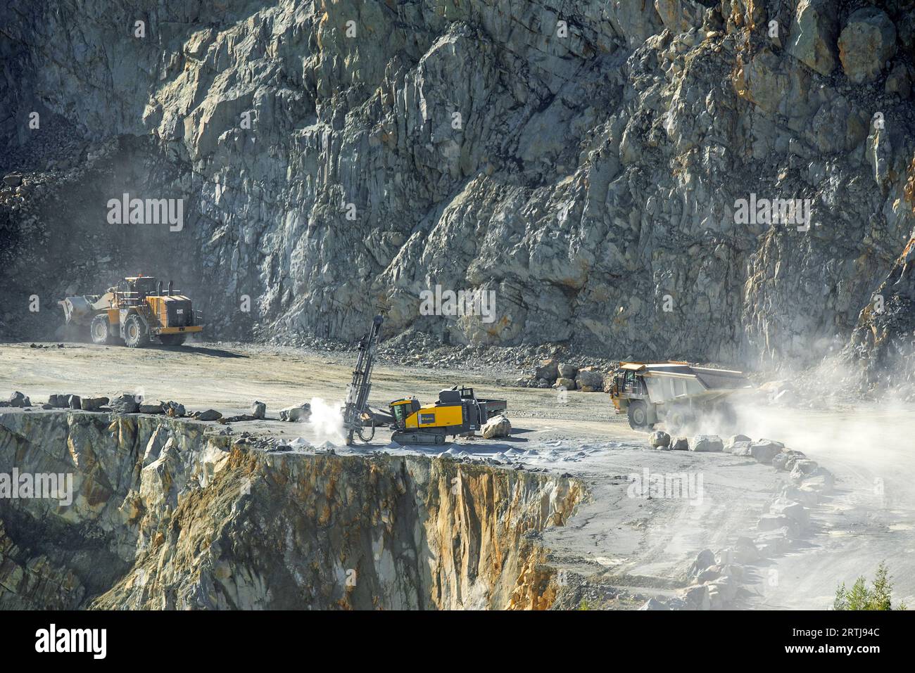 Engin de forage de surface, bulldozer et camion de transport dans la carrière de porphyre, mine à ciel ouvert pour le gravier pour la construction de routes à Lessen / Lessines, Hainaut, Belgique Banque D'Images