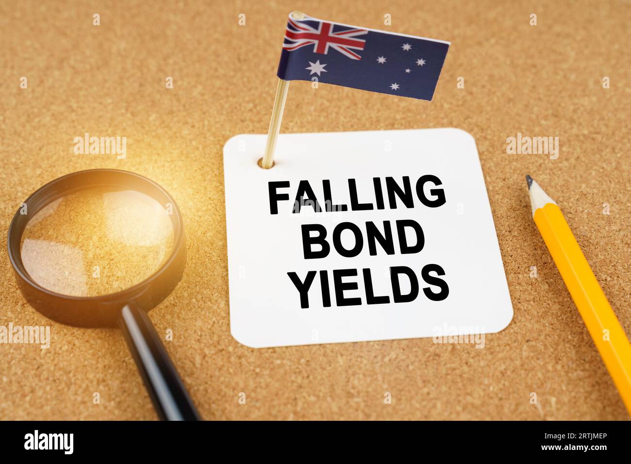 Concept d'économie et de finance. Sur la table se trouvent une loupe, un crayon, le drapeau de l'Australie et une feuille de papier avec l'inscription - Falling Banque D'Images