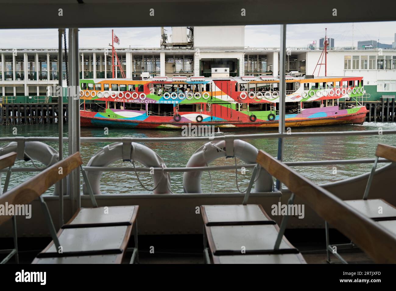 Star Ferry coloré vu depuis le coin salon d'un autre ferry. Focus sélectif sur le ferry coloré. Hong Kong - 25 août 2023 Banque D'Images