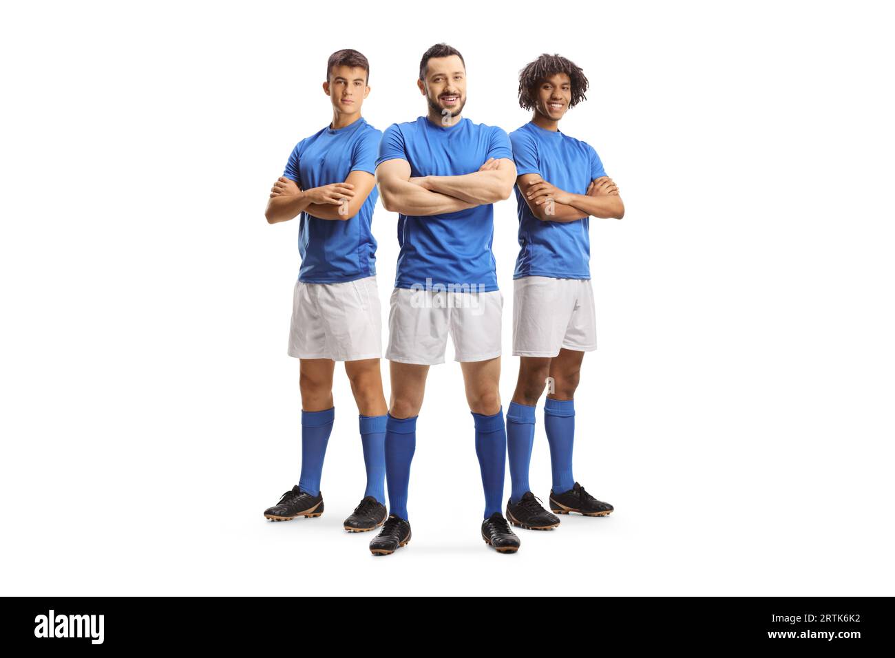 Trois joueurs de football en maillots bleus posant isolé sur fond blanc Banque D'Images