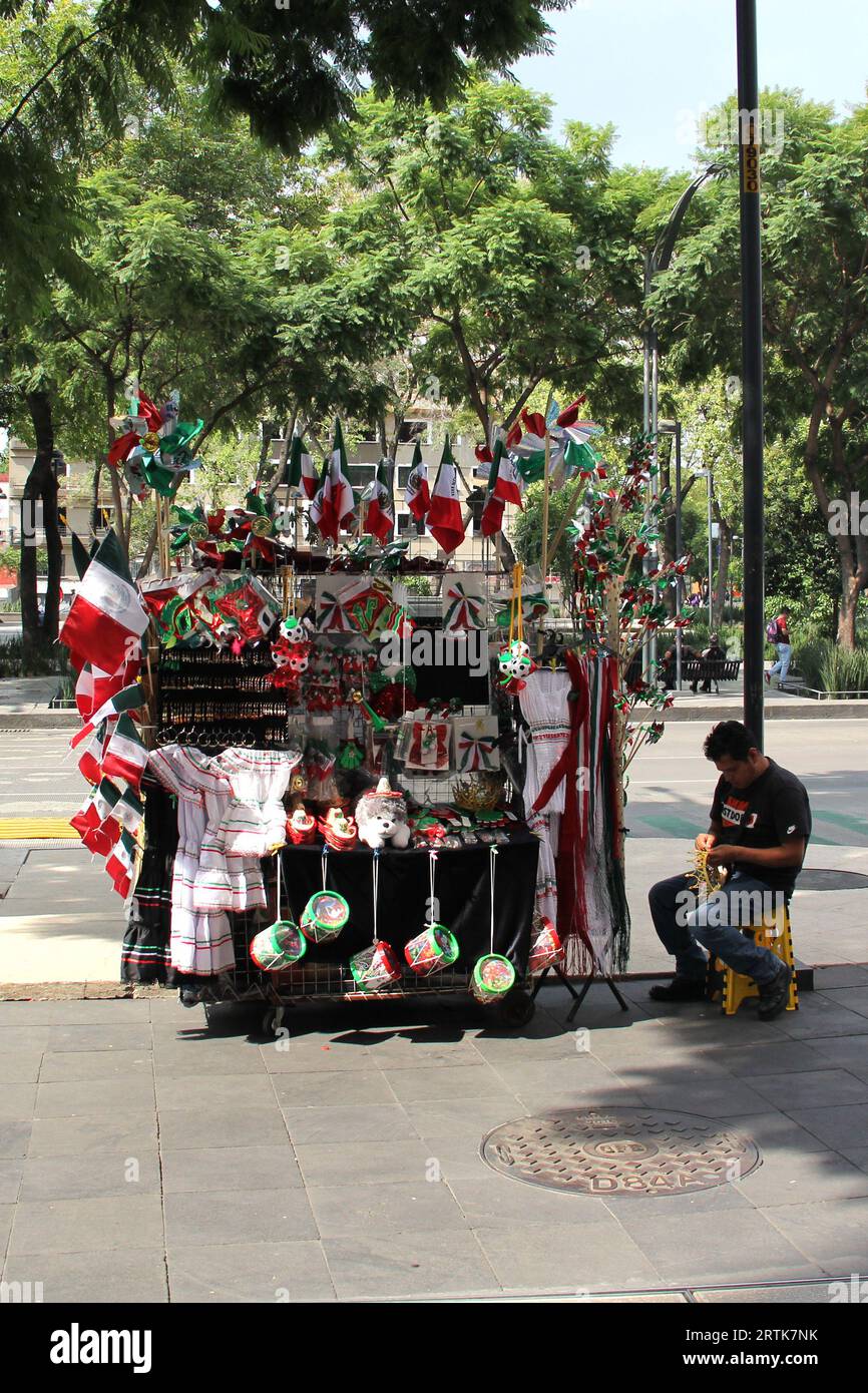 Mexico, Mexique - 6 septembre 2023 : Stall de rue vendant des drapeaux tricolores mexicains, des roues d'épingle, des chapeaux et d'autres articles nationaux Banque D'Images