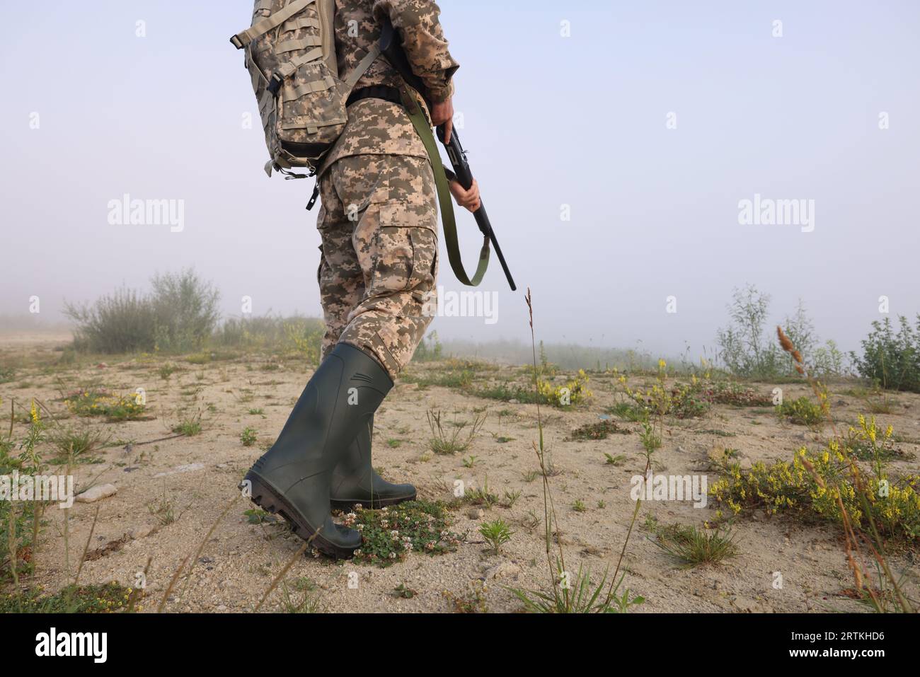 Homme portant le camouflage avec fusil de chasse et sac à dos à l'extérieur, gros plan. Espace pour le texte Banque D'Images