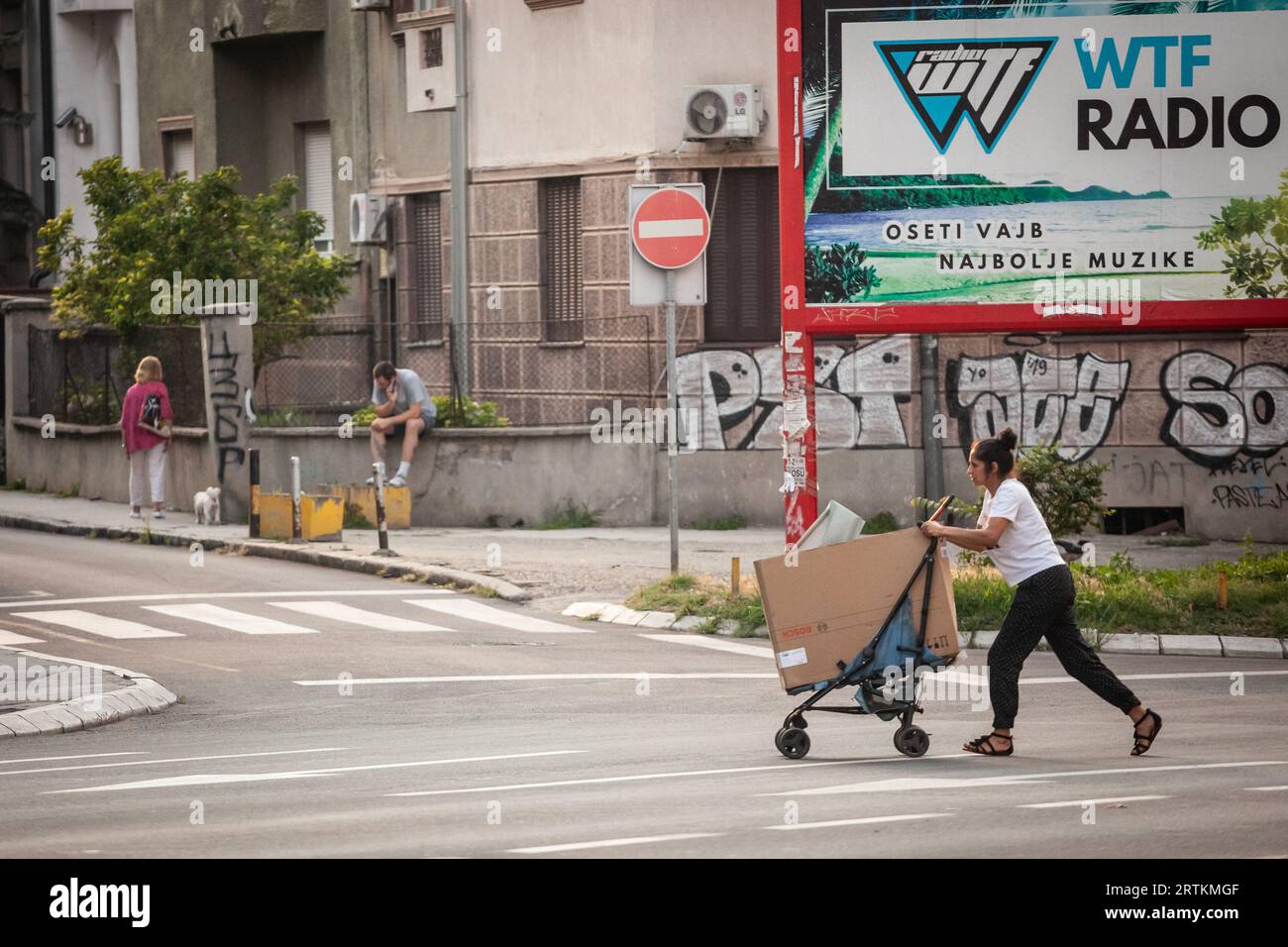 Photo d'une jeune femme appartenant à la communauté rom passant dans les rues de Belgrade Serbie, pour acheter et ramasser des ordures et recycler ce qui est Banque D'Images