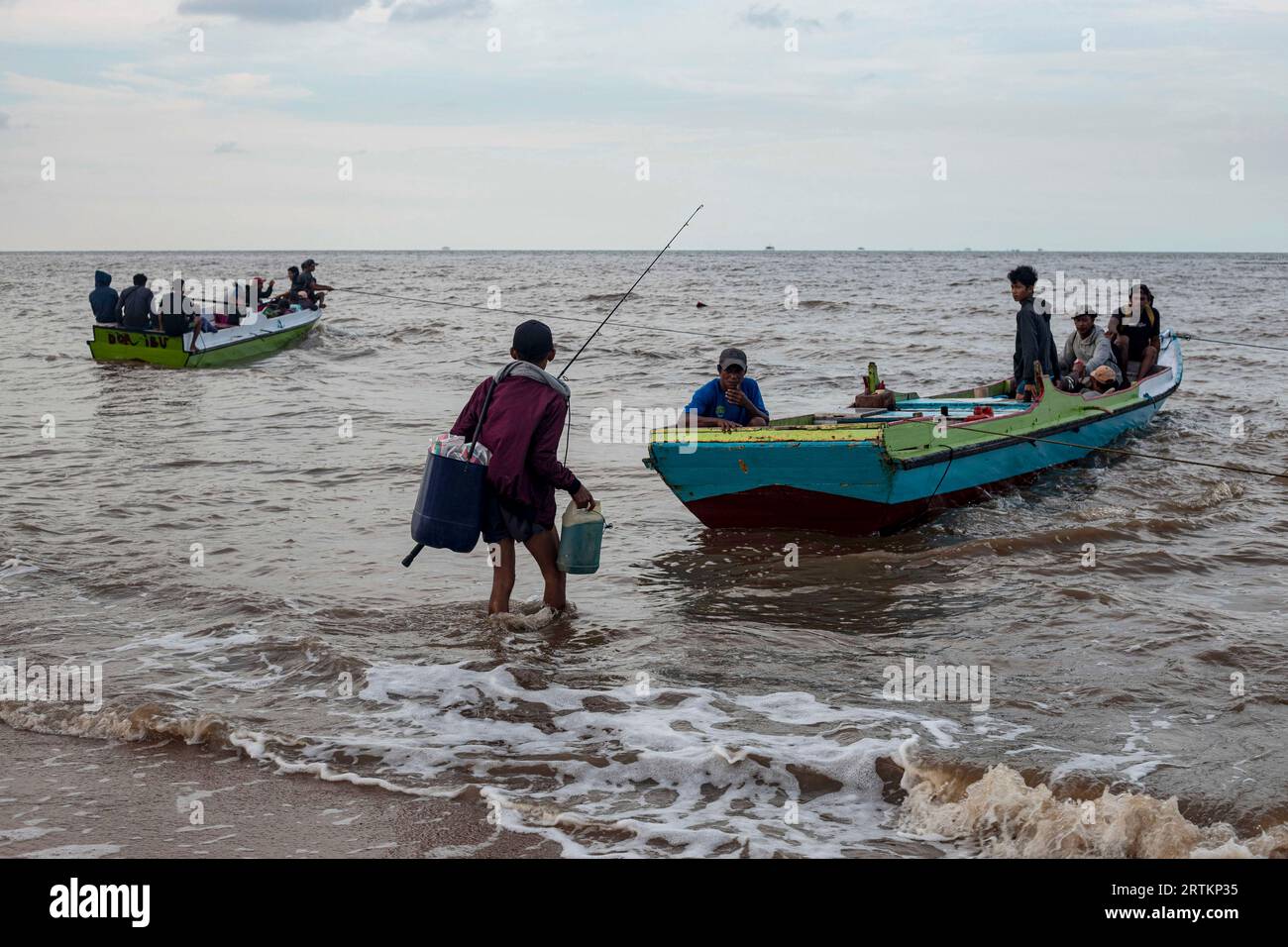 Fishermen prepare to leave on a beach in Tanah Kuning, near the site for the future development of the Kalimantan Industrial Park Indonesia, in North Kalimantan, Indonesia, Wednesday, Aug. 23, 2023. The industrial park being built in Indonesia on the tropical island of Borneo that has attracted billions of dollars in foreign and domestic investment is damaging the environment in an area where endangered species live and migrate. (AP Photo/Yusuf Wahil) Banque D'Images