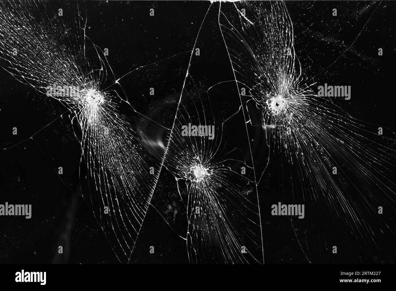 Verre cassé avec texture de trous de balle sur fond noir Banque D'Images
