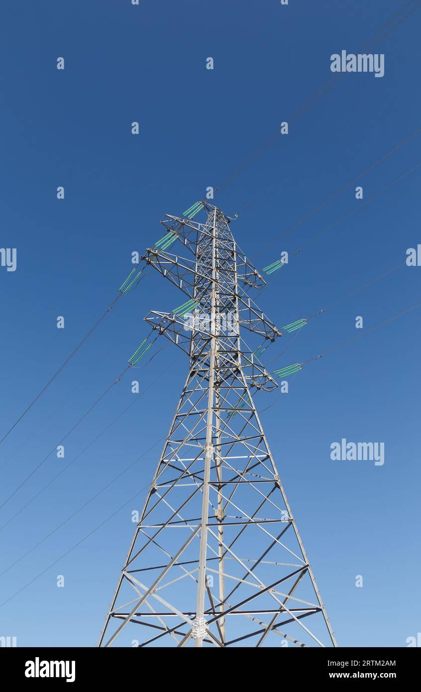 Haut pylône d'une ligne électrique contre le ciel bleu Banque D'Images