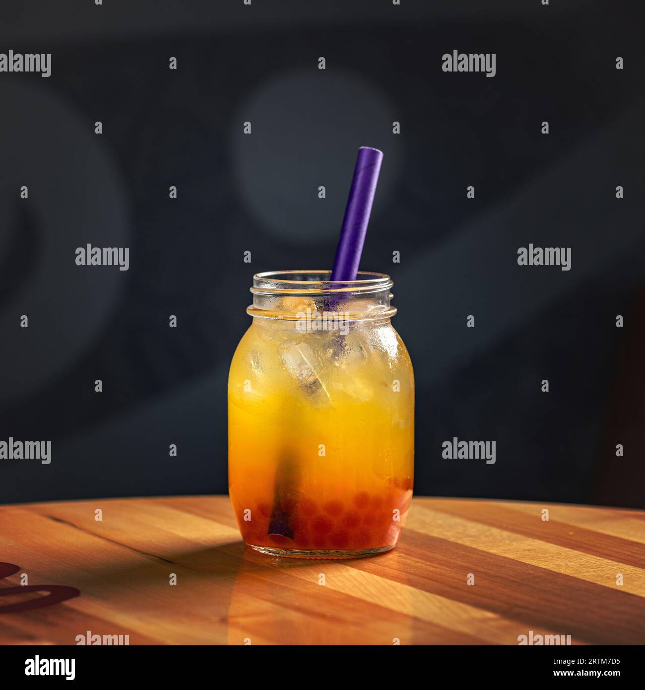 Boisson aux baies d'été avec des boules de gelée dans un bocal en verre avec de la paille à boire en papier Banque D'Images