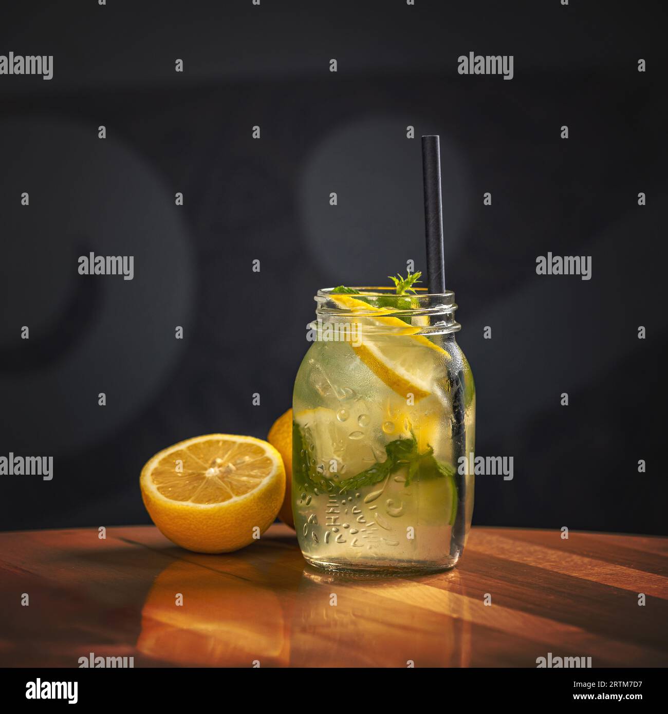 Eau citronnée, limonade en bocal. Couper des citrons en arrière-plan. Limonade naturelle. Banque D'Images
