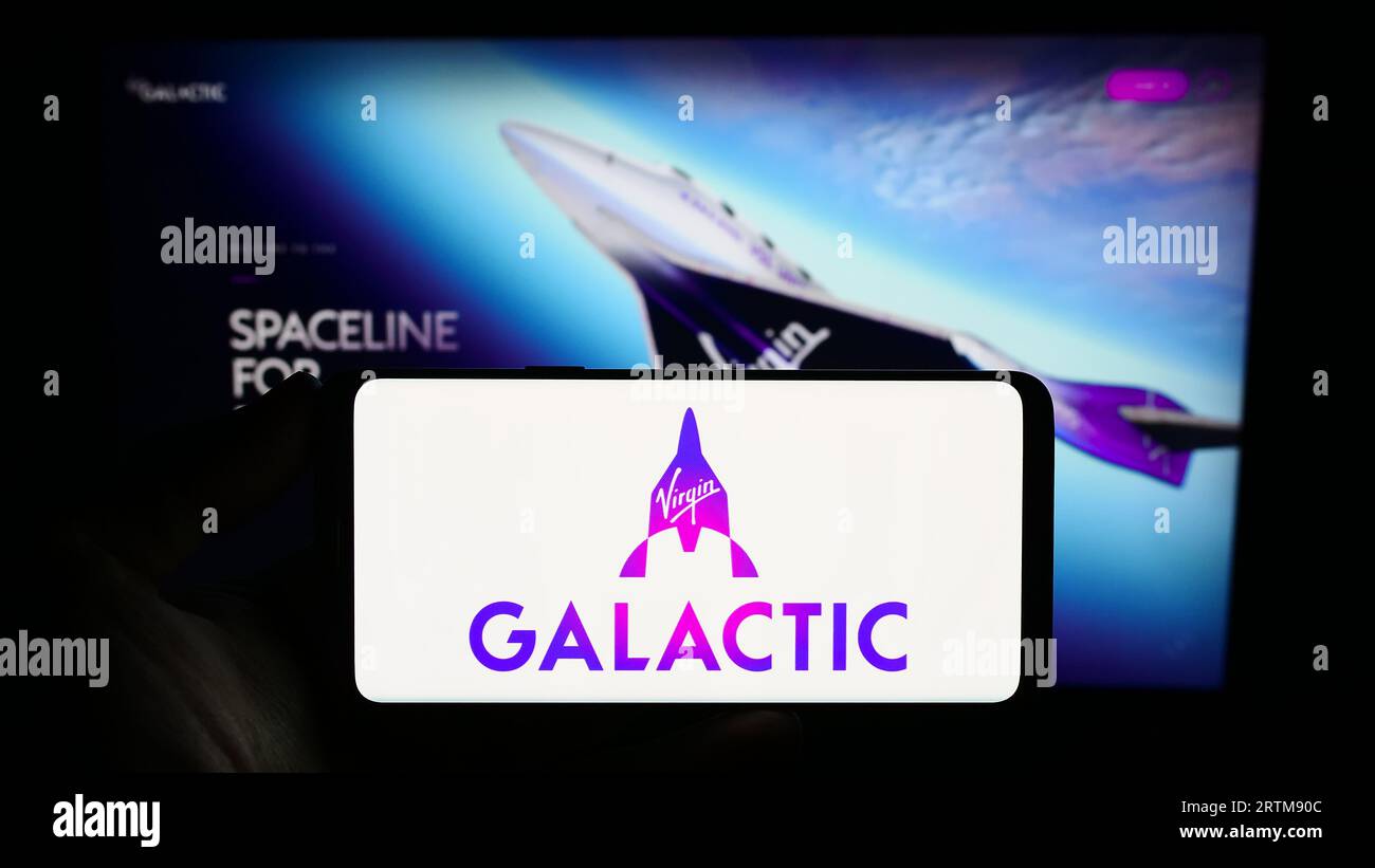 Personne tenant le téléphone portable avec le logo de la compagnie américaine de vol spatial Virgin Galactic sur l'écran en face de la page Web de l'entreprise. Concentrez-vous sur l'affichage du téléphone. Banque D'Images