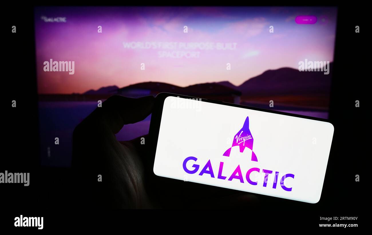 Personne tenant le smartphone avec le logo de la compagnie américaine de vol spatial Virgin Galactic sur l'écran en face du site Web. Concentrez-vous sur l'affichage du téléphone. Banque D'Images