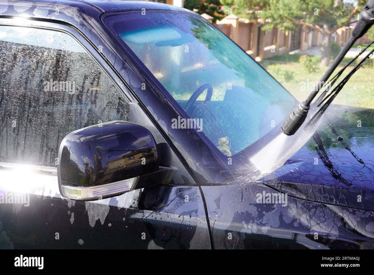 homme laver la voiture avec lavage de voiture - nettoyeur haute pression , shampooing, éponges et serviettes de voiture en microfibre Banque D'Images