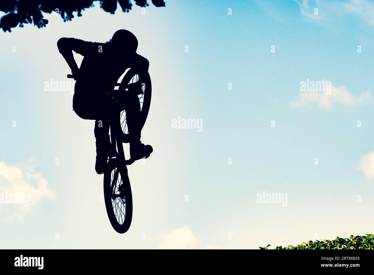 Silhouette d'un motard effectuant un saut extrêmement sale avec un vélo bmx contre le ciel Banque D'Images