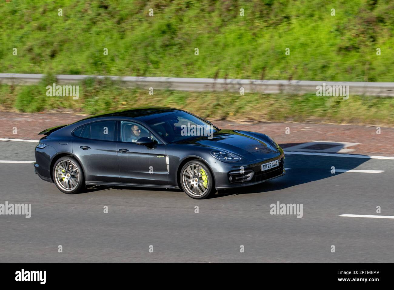 2022 gris Porsche Panamera 4 eHyb Platinium, voiture de sport pour quatre ; voyageant à grande vitesse sur l'autoroute M6 dans le Grand Manchester, Royaume-Uni Banque D'Images