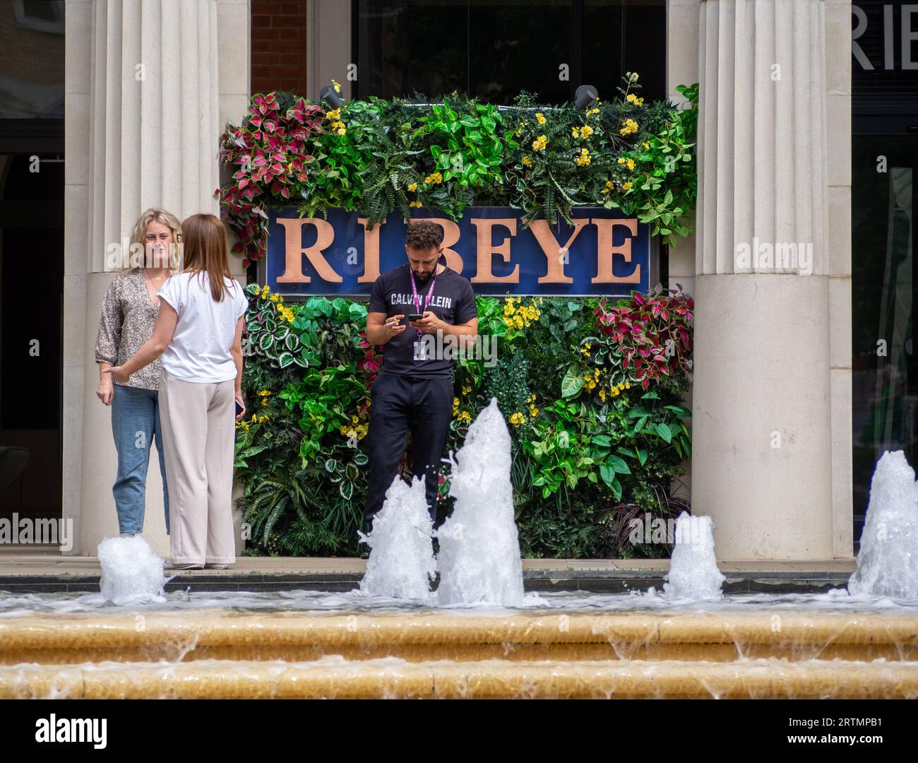 Les gens debout devant la façade attrayante de Ribeye, un restaurant de steak à Brindley place, Birmingham, Royaume-Uni Banque D'Images