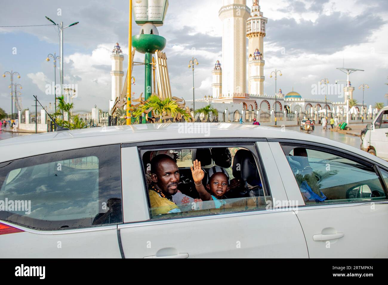 Passagers de voiture et grande mosquée à Touba, Sénégal Banque D'Images