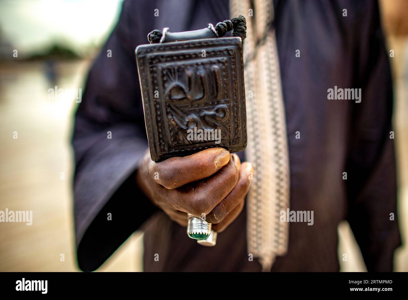 Dévot musulman montrant une amulette avec des écritures coraniques dans la grande mosquée de Touba, Sénégal Banque D'Images