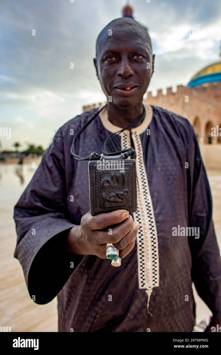 Dévot musulman montrant une amulette avec des écritures coraniques dans la grande mosquée de Touba, Sénégal Banque D'Images