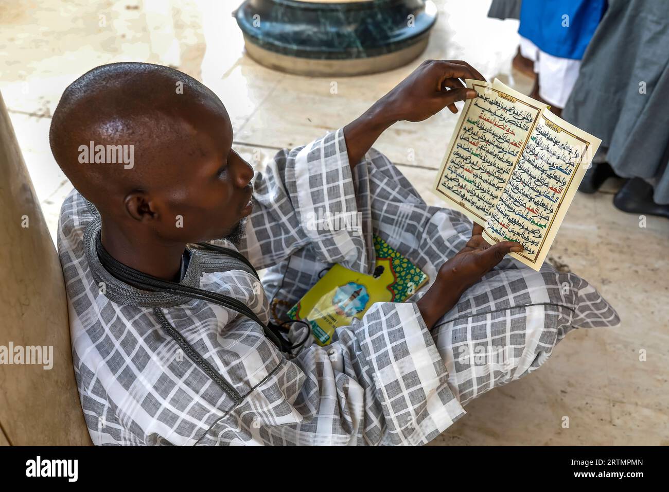 Musulman lisant les écritures coraniques dans la grande mosquée de Touba, Sénégal Banque D'Images