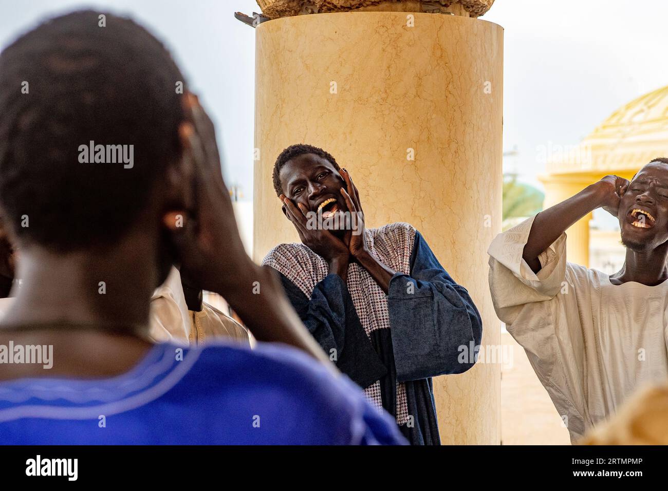 Des dévots chantant des vers coraniques dans la grande mosquée de Touba, Sénégal Banque D'Images