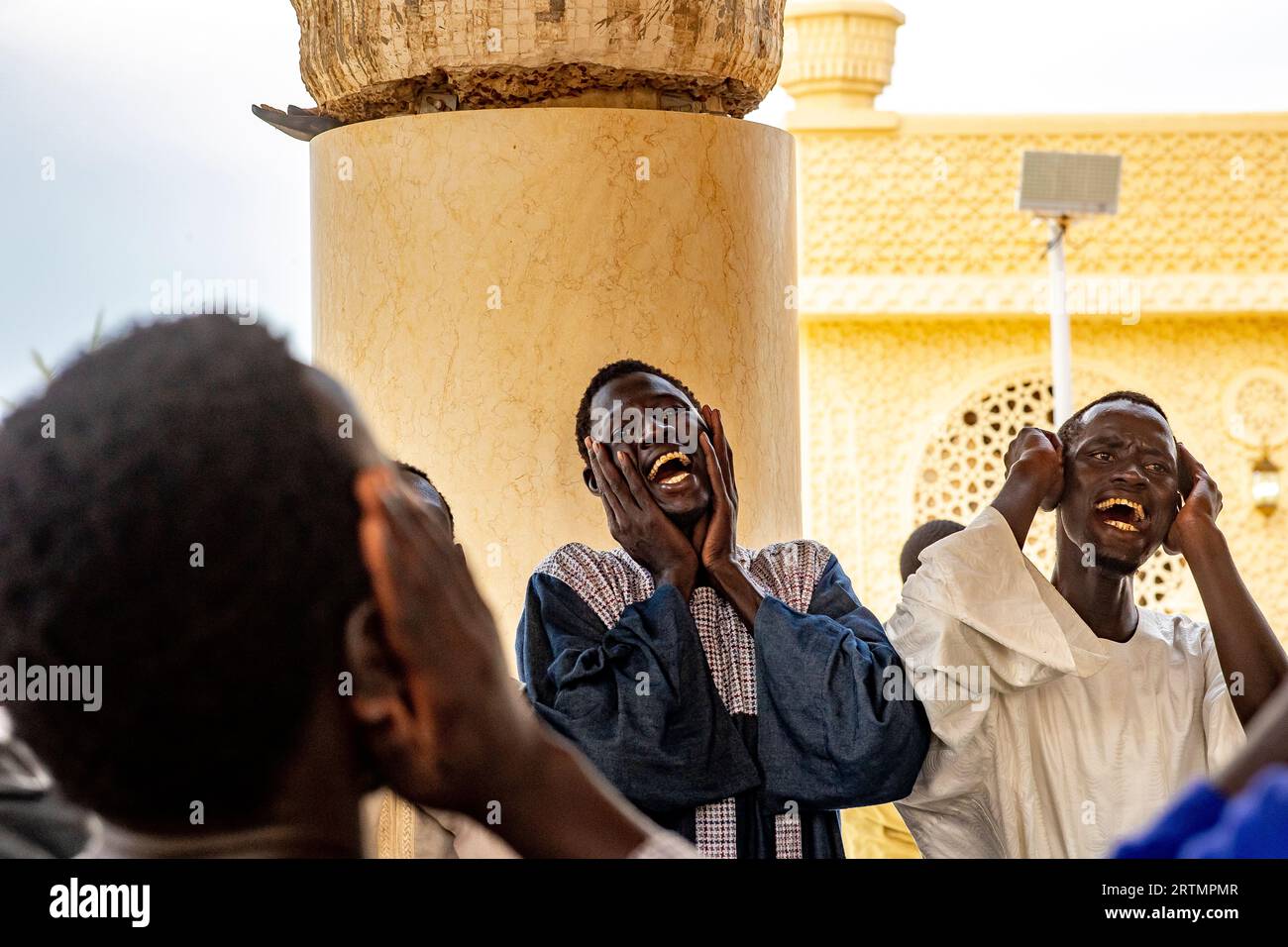 Des dévots chantant des vers coraniques dans la grande mosquée de Touba, Sénégal Banque D'Images