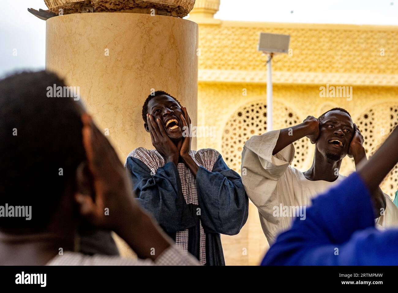 Des dévots chantant des vers coraniques dans la grande mosquée de Touba, Sénégal Banque D'Images